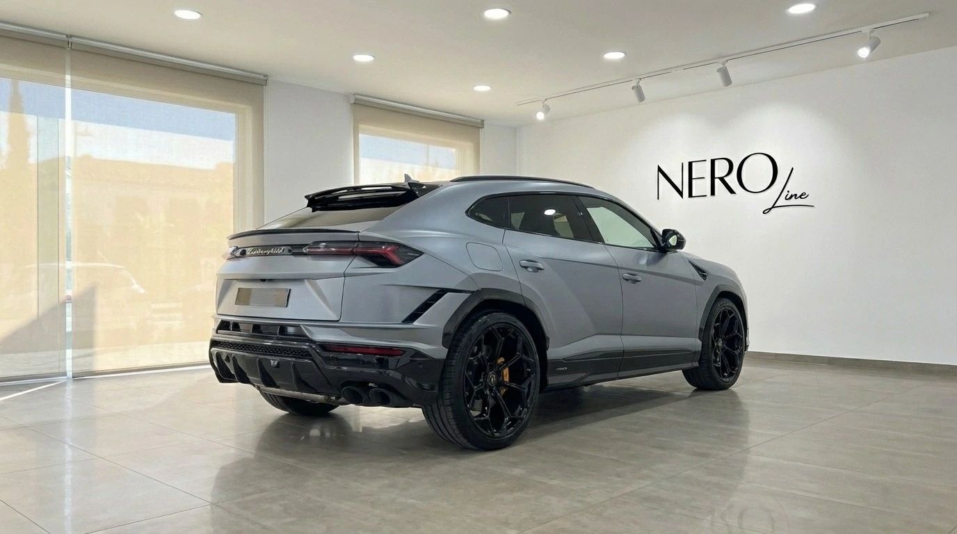 El Lamborghini Urus Performante gris mate se exhibe desde una vista trasera tres cuartos en un luminoso showroom en Madrid.