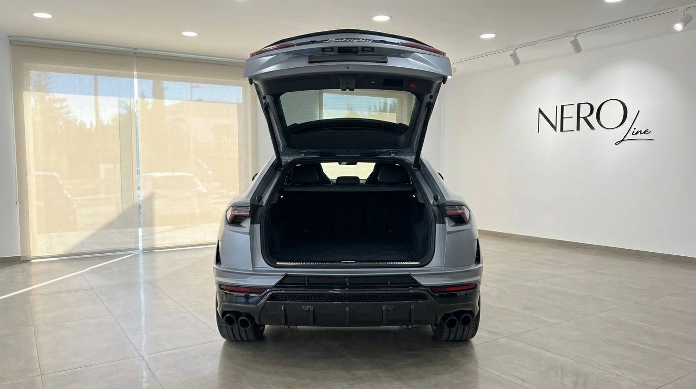 El Lamborghini Urus Performante gris mate, visto desde atrás con el maletero abierto, revela su espacioso compartimento de carga en Madrid.