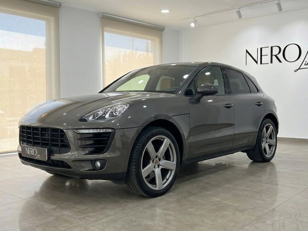Porsche Macan 2.0 Turbo — Showroom en Alicante El Porsche Macan 2.0 Turbo gris volcán metálico brillante se exhibe desde un ángulo frontal tres cuartos en un showroom en Alicante.
