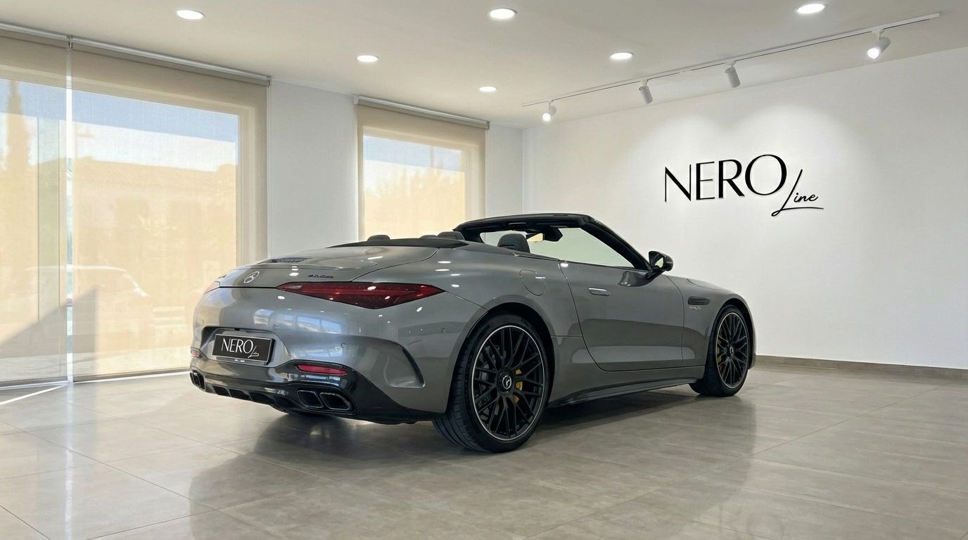The silver-grey Mercedes-Benz AMG GT Roadster is shown from the rear three-quarter with its top down in a showroom in Ibiza.