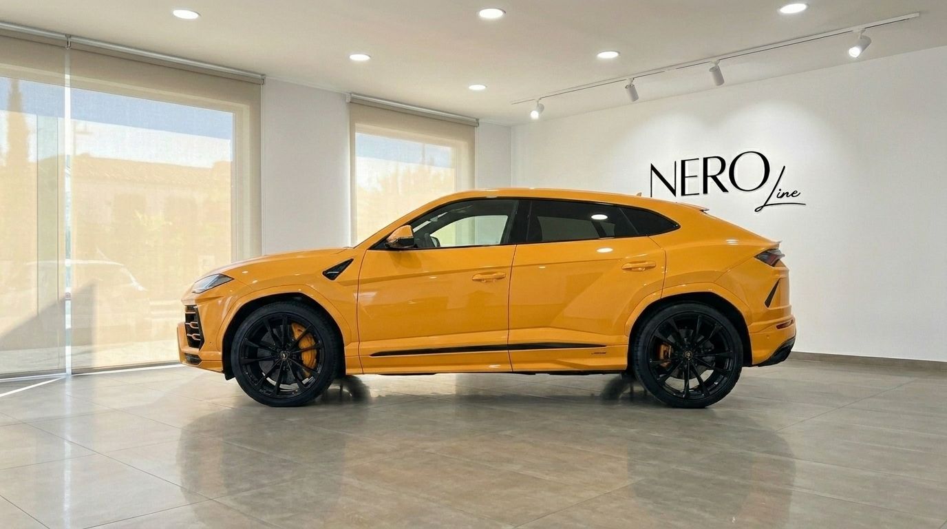 The orange Lamborghini Urus S is showcased in a side profile view inside a bright showroom in Barcelona.