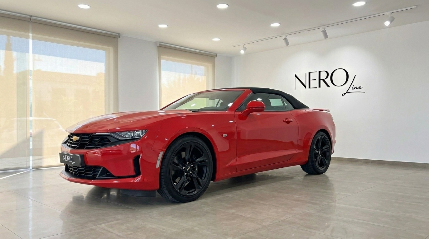 Chevrolet Camaro — Red Convertible in Alicante Showroom A striking red Chevrolet Camaro convertible is showcased from a front three-quarter angle in a modern showroom in Alicante.