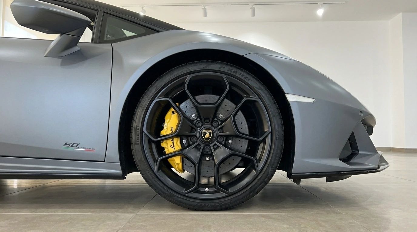 The front wheel of the matte gray Lamborghini Huracan Evo Spyder 60th Anniversary with yellow brake calipers, seen in Ibiza.