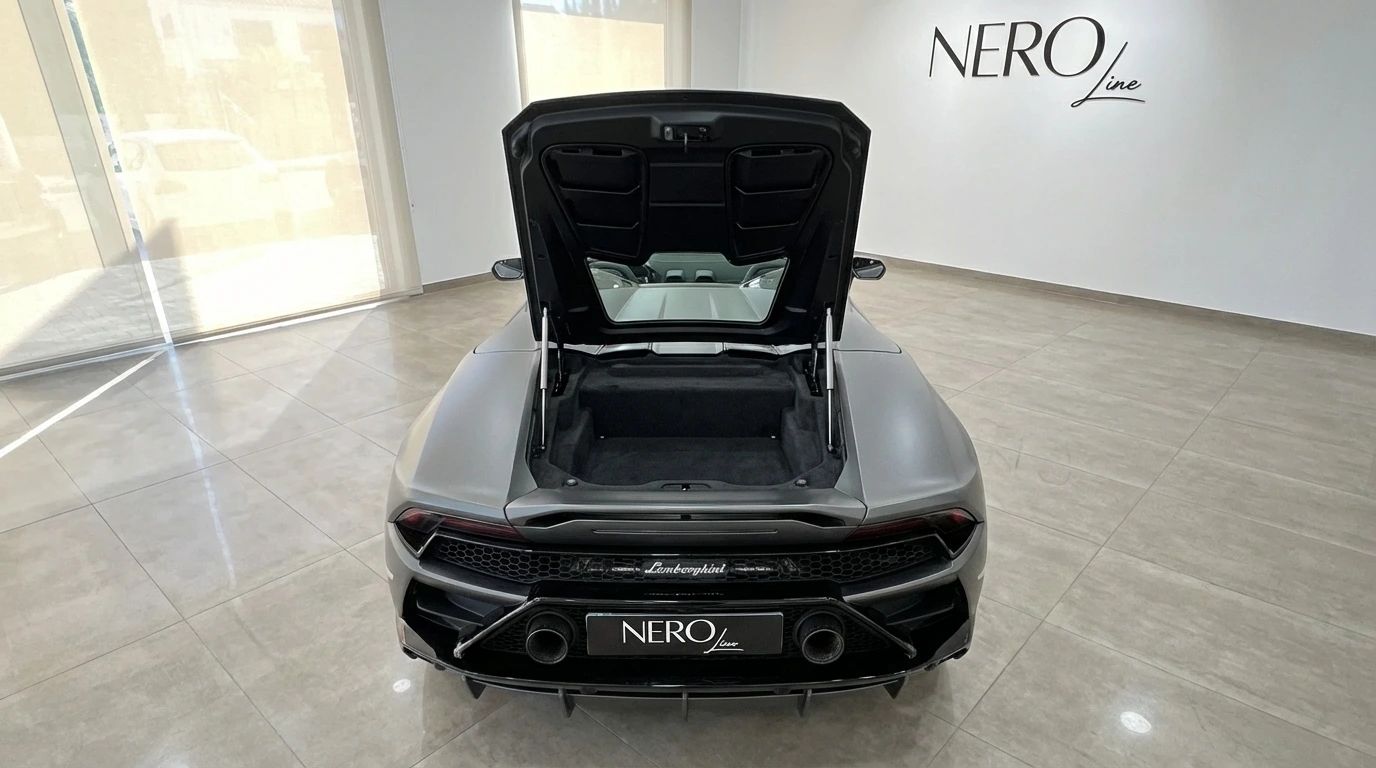 Rear view of the matte gray Lamborghini Huracan Evo Spyder 60th Anniversary with its trunk open, parked in a showroom in Ibiza.