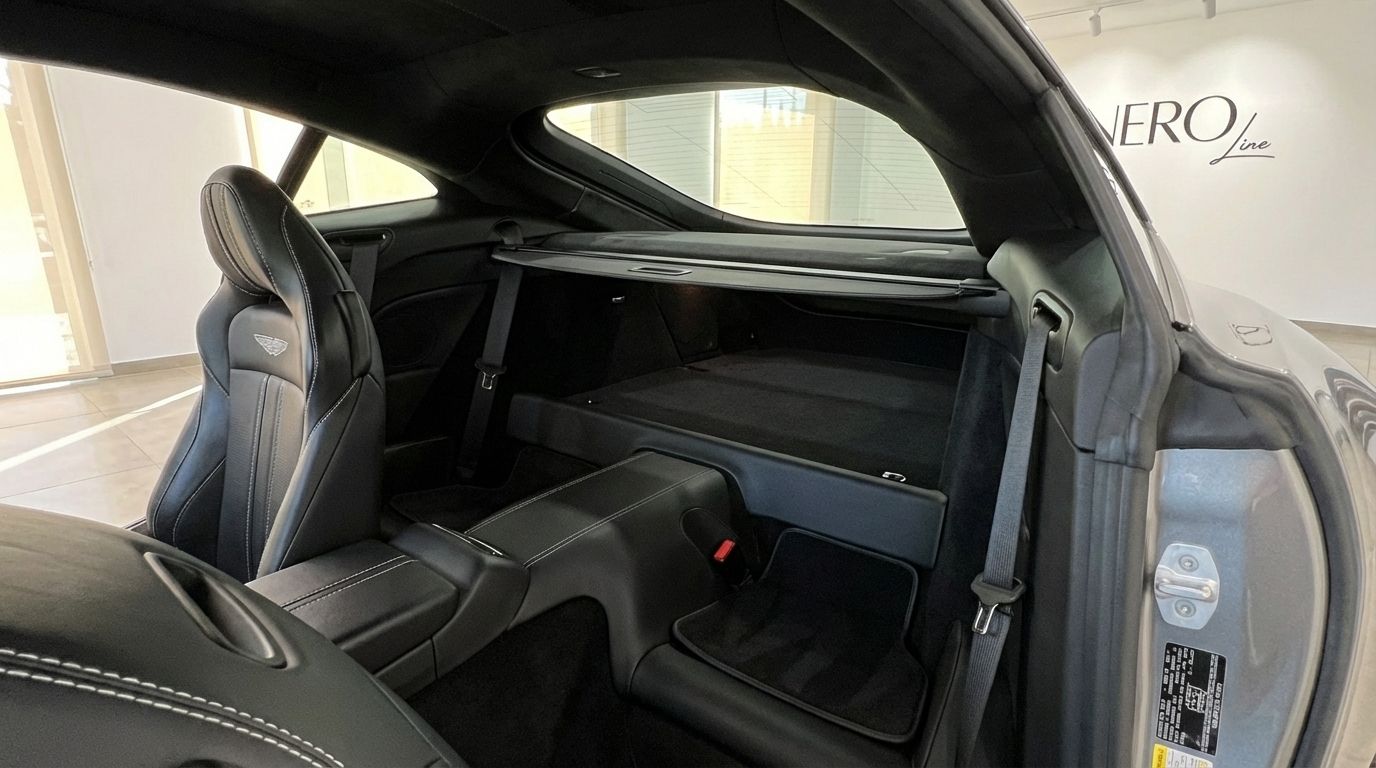 View of the Aston Martin Vantage V8's luxurious black leather interior, showcasing the rear seats and spacious storage area in Marbella.