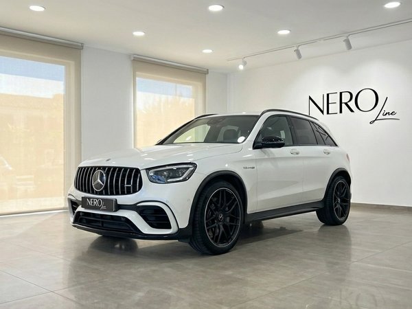 Mercedes-Benz GLC 63 S AMG — Front view Marbella The white 2022 Mercedes-Benz GLC 63 S AMG performance SUV is showcased from a front three-quarter view in a Marbella showroom.