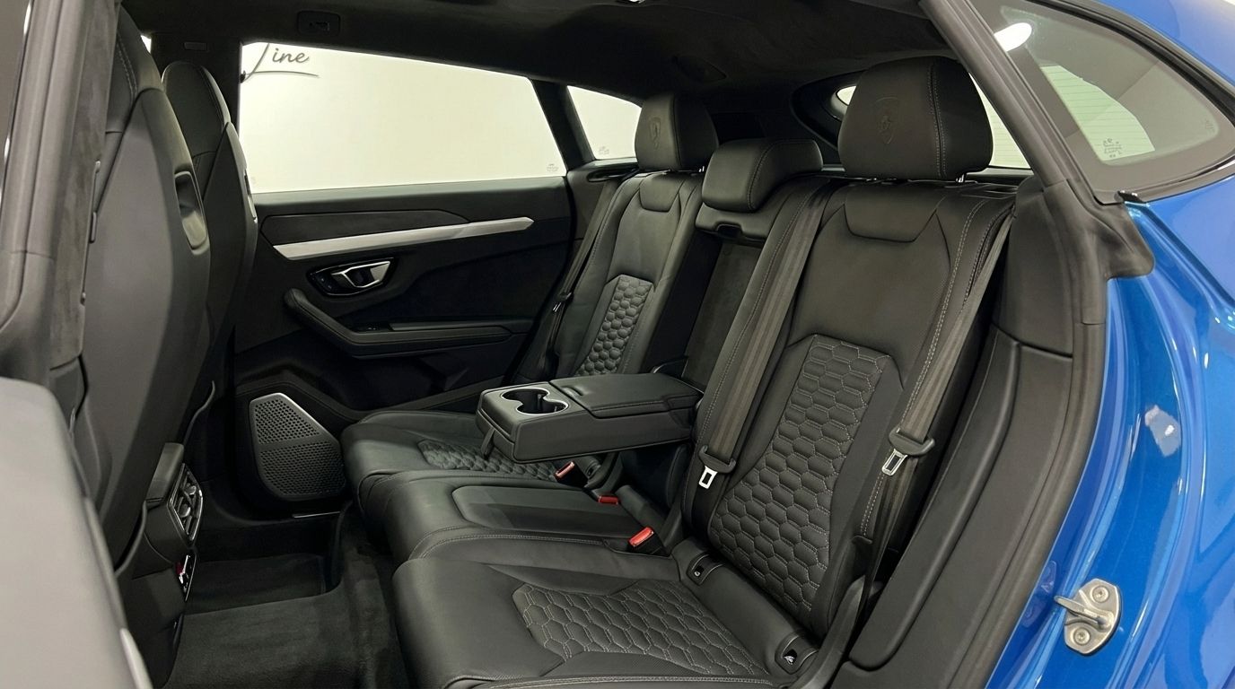 The luxurious black leather rear seats with distinctive honeycomb stitching and a central armrest with cup holders in the Lamborghini Urus in Mallorca.