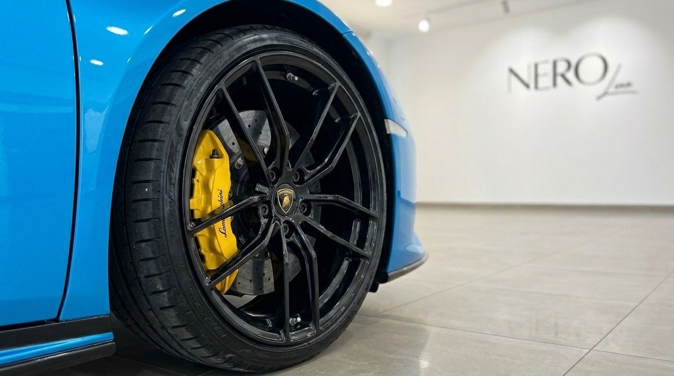 Primer plano de la rueda negra y la pinza de freno amarilla del Lamborghini Huracán LP610-4 azul en Madrid.