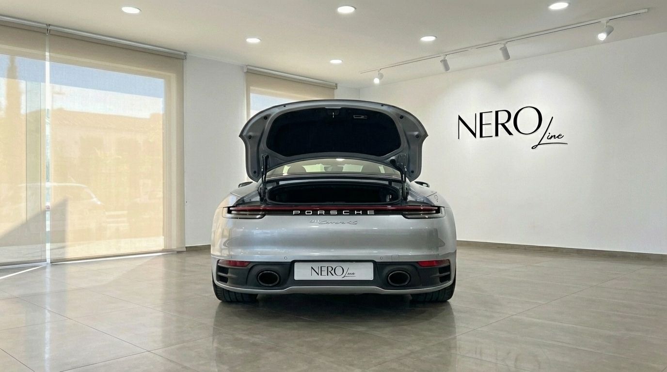 The metallic silver Porsche 911 Carrera 4S Targa 992 is shown from the rear with its trunk open in a Marbella showroom.
