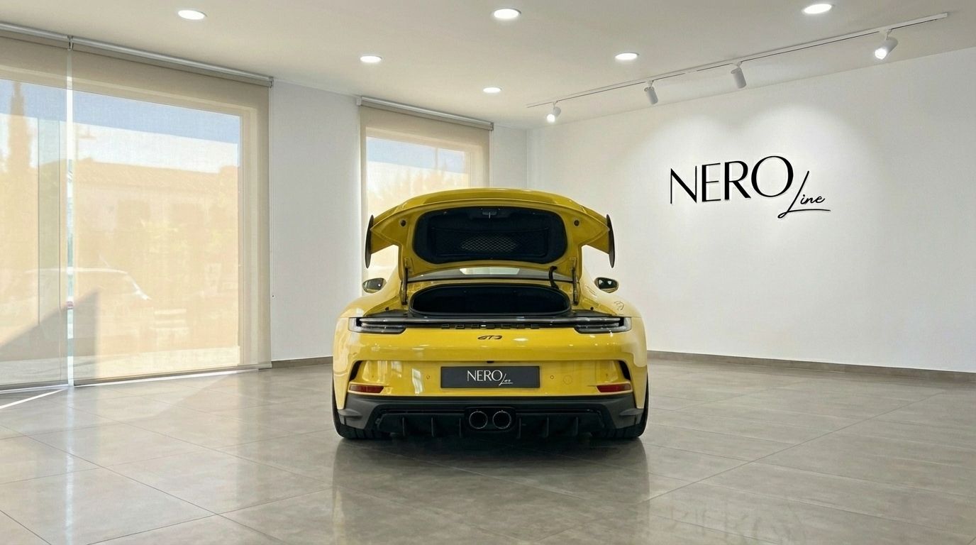 Porsche 911 GT3 992 gialla vista da dietro con il bagagliaio aperto, parcheggiata in uno showroom ad Alicante.