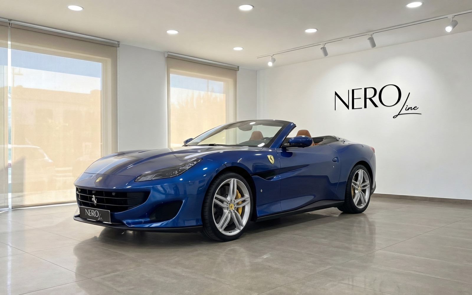 Ferrari Portofino — Metallic blue convertible in Malaga The metallic blue 2022 Ferrari Portofino convertible is showcased from a front three-quarter view in a showroom in Malaga.