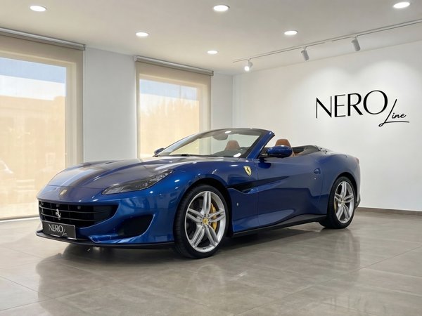 Ferrari Portofino — Metallic blue convertible in Malaga The metallic blue 2022 Ferrari Portofino convertible is showcased from a front three-quarter view in a showroom in Malaga.