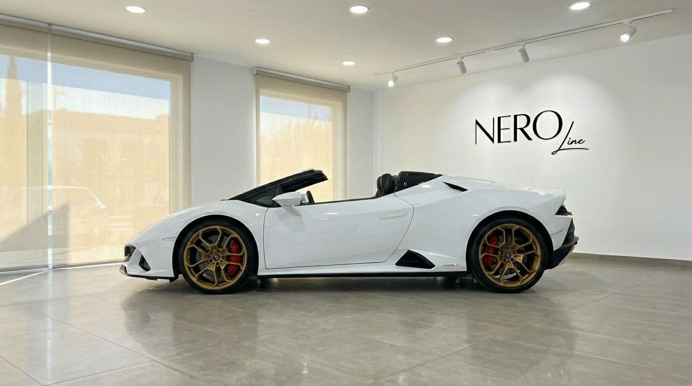 The white Lamborghini Huracan Evo Spyder convertible, with its top down and gold wheels, is displayed in a showroom in Alicante.