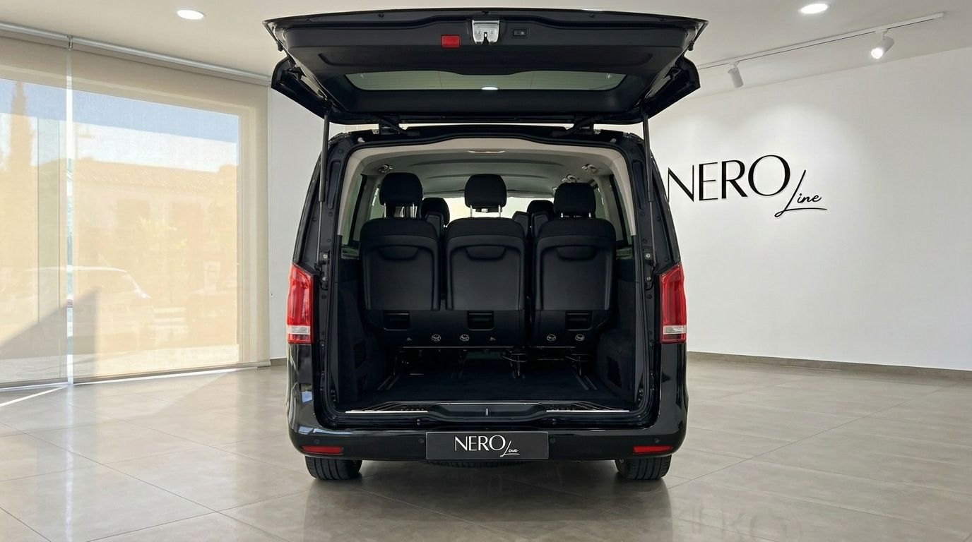 Mercedes-Benz V-Class in gloss Obsidian Black, showing the open rear trunk with three passenger seats and ample cargo space in Marbella.