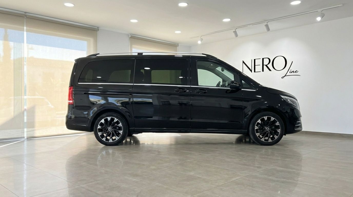 The black Mercedes-Benz V-Class luxury van is shown in a side profile view inside a showroom in Marbella.