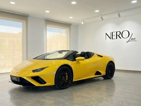 Lamborghini Huracan EVO Spyder — Showroom Madrid El Lamborghini Huracan EVO Spyder amarillo de 2024 se exhibe desde una vista frontal de tres cuartos en un luminoso showroom de Madrid.