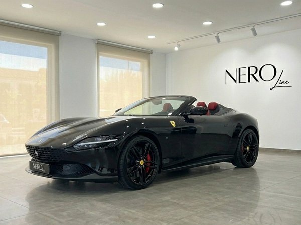 Ferrari Roma Spider Black — Showroom Madrid The 2025 Ferrari Roma Spider Black, with its top down and red interior, is showcased in a Madrid showroom.