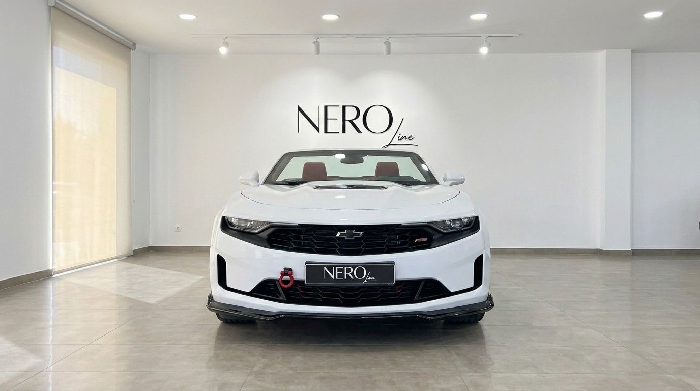 The white Chevrolet Camaro Cabrio 3.6 is shown from the front with its top down, revealing the red interior in a showroom in Alicante.