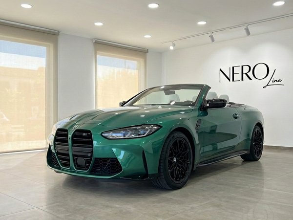 BMW M4 Competition Convertible — Showroom view The emerald green BMW M4 Competition Convertible is showcased in a showroom with its top down, highlighting its sleek design in Alicante.
