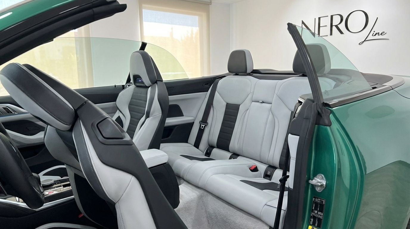 The interior of the emerald green BMW M4 Competition Convertible in Alicante, showcasing its light grey and black sports seats.