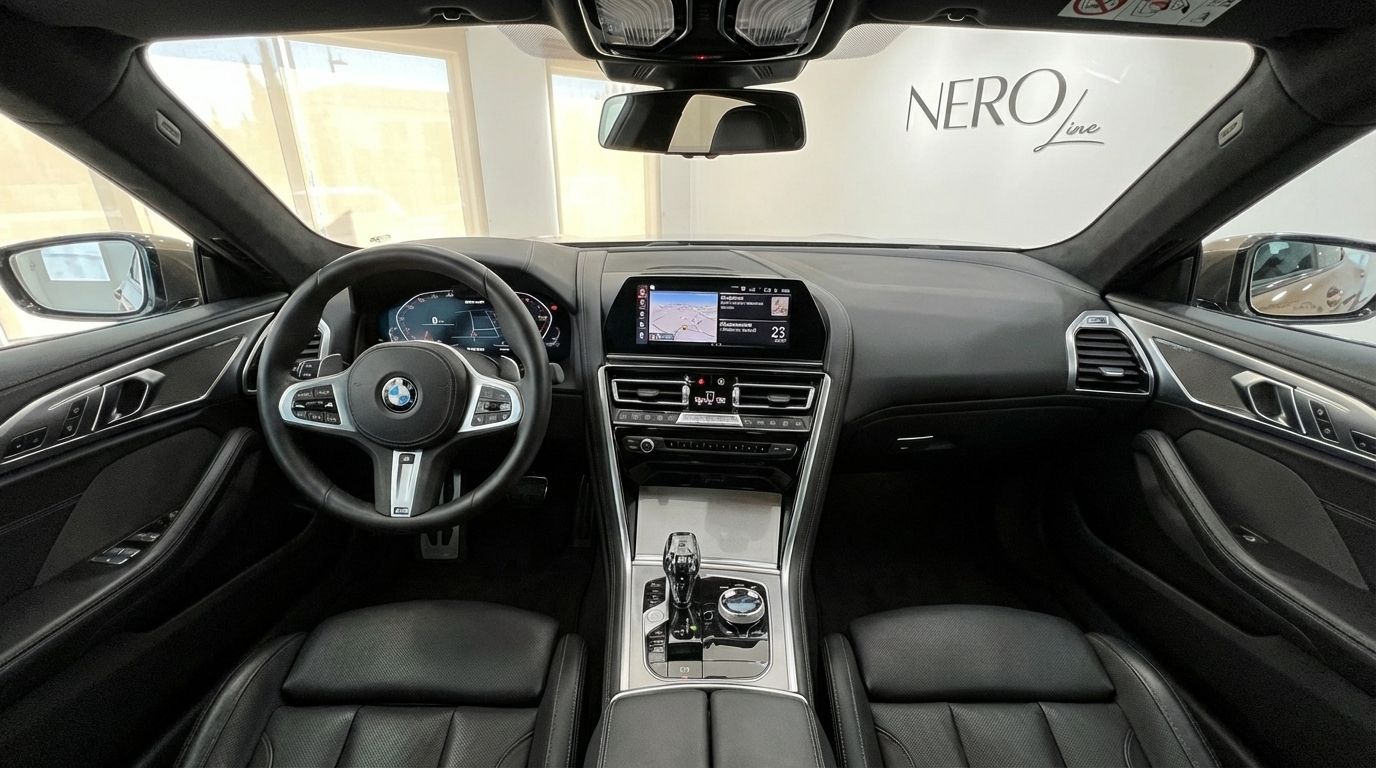 The luxurious black leather interior and modern cockpit of the BMW M850i Grandcoupe, featuring the steering wheel and infotainment system in Barcelona.