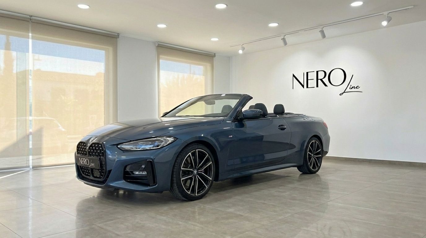 The dark blue BMW 420 Cabriolet is displayed with its top down, showcasing its sleek design in a showroom in Alicante.