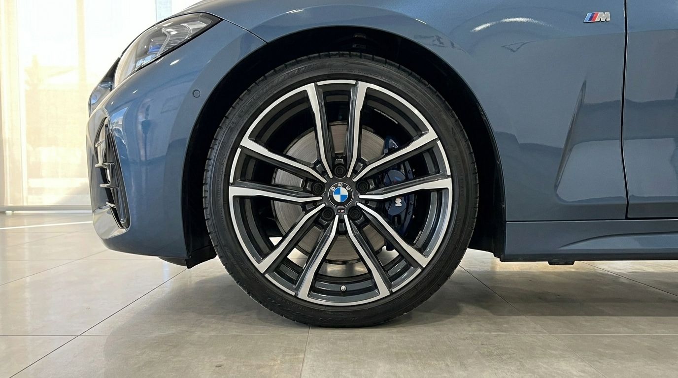 Close-up of the BMW 420 Cabriolet's front wheel with multi-spoke rims and blue M Sport calipers in Alicante.