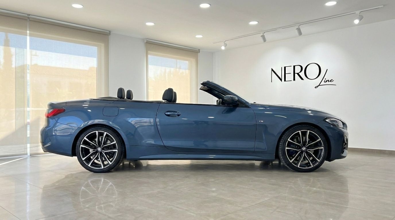 The blue BMW 420 Cabriolet is shown in a side profile view with its convertible top down, parked inside a modern showroom in Alicante.