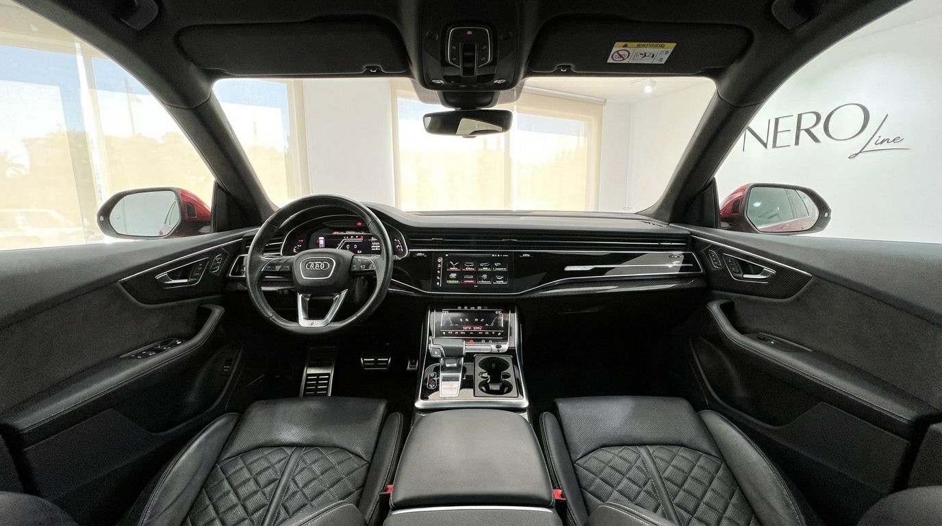 The luxurious black interior of the Audi SQ8, featuring the steering wheel, dashboard, and quilted leather seats in Alicante.