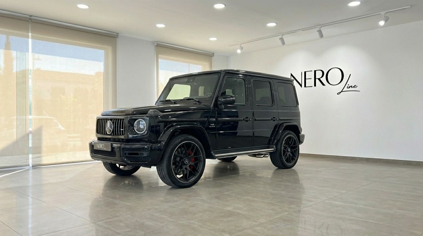 A glossy black Mercedes-Benz AMG G 63, presented from a front three-quarter view, parked indoors in Alicante.