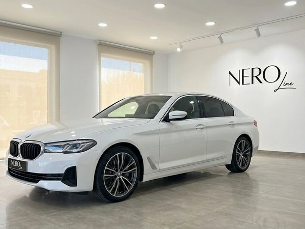 BMW 530e xDrive — Front three-quarter view Alicante The white 2022 BMW 530e xDrive is showcased from a front three-quarter angle in a showroom in Alicante.