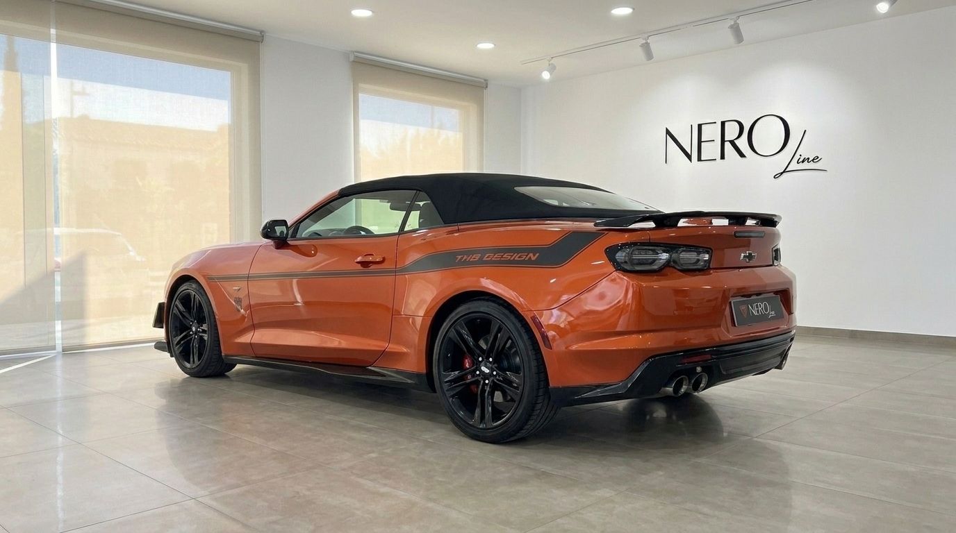 A glossy metallic orange Chevrolet Camaro Cabriolet 6.2, with a black soft top and "THS DESIGN" decal, is parked in Alicante.