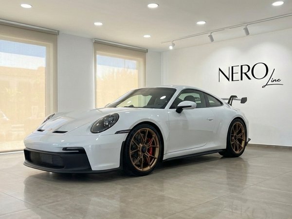 Porsche 911 GT3 992 — Showroom view The white Porsche 911 GT3 992 is showcased in a Marbella showroom, featuring its striking front three-quarter view and bronze wheels.