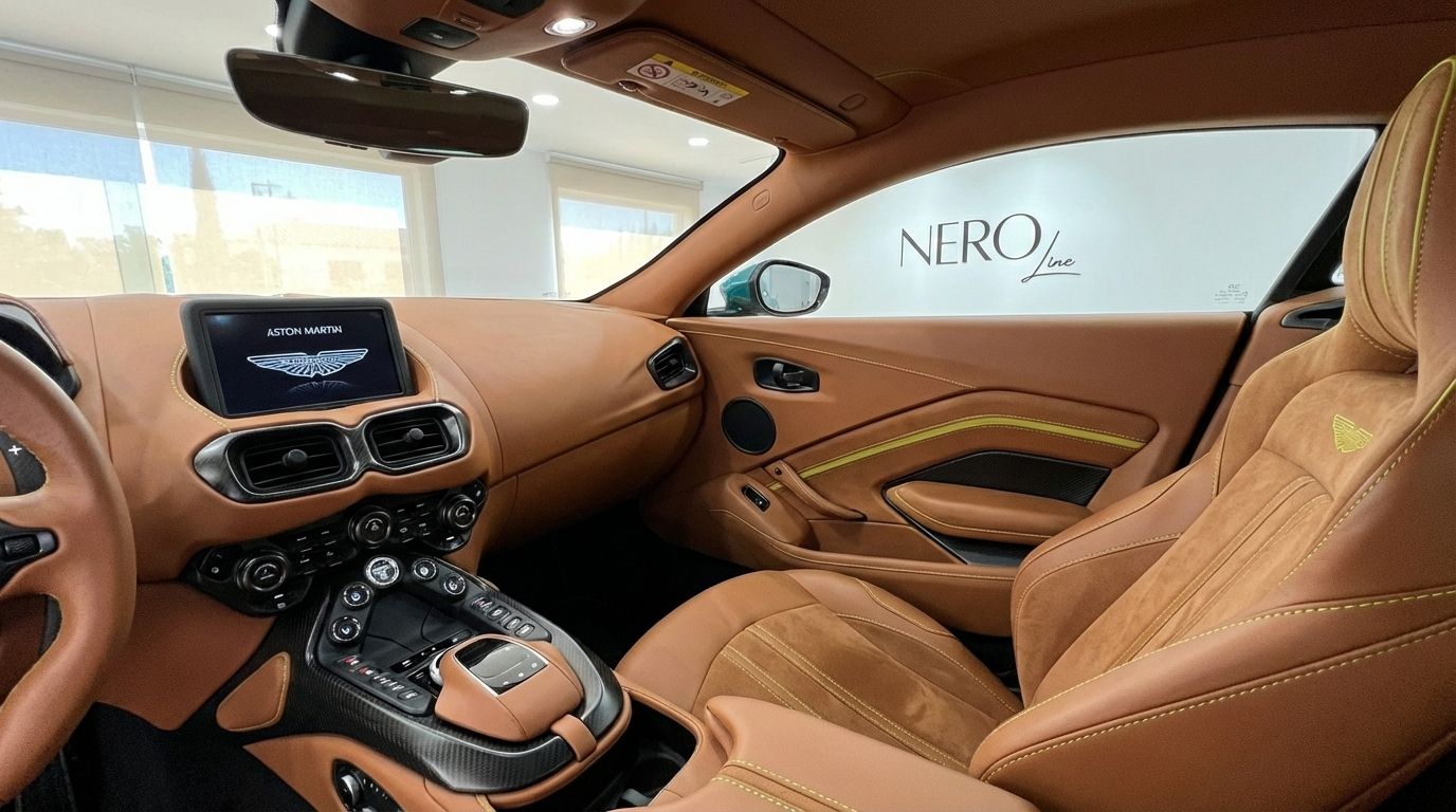 The luxurious brown leather and Alcantara interior of the Aston Martin Vantage F1 Spec, showcasing the dashboard, central console, and passenger seat in Alicante.