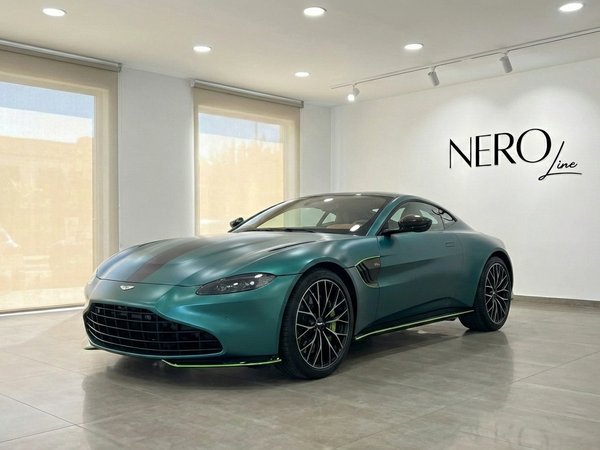 Aston Martin Vantage F1 Spec — Indoor Display The metallic green 2024 Aston Martin Vantage F1 Spec is parked indoors, showcasing its sleek front three-quarter view in Alicante.