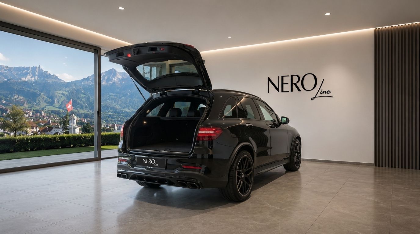 The black Mercedes-Benz GLC 63 AMG is shown from the rear with its trunk open in a Zurich showroom, overlooking mountains.