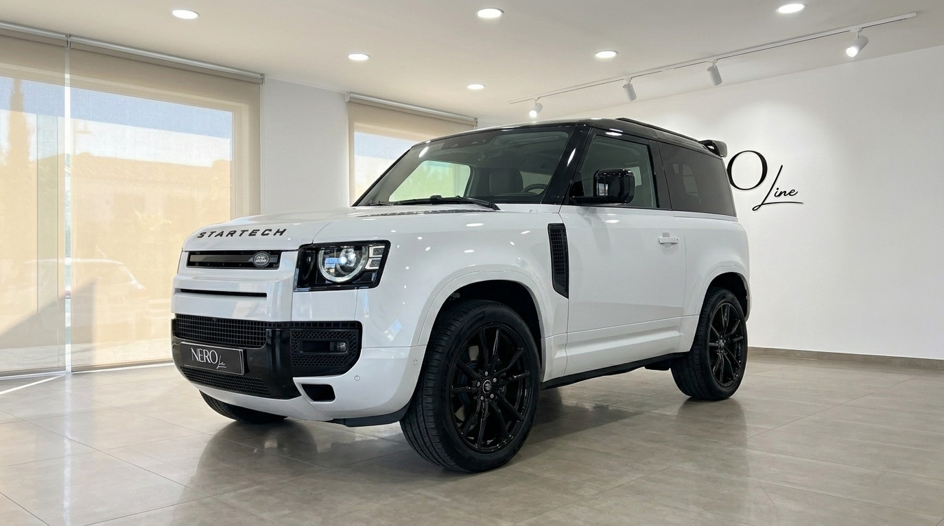 Land Rover Defender 90 Startech — Marbella Showroom The white Land Rover Defender 90 Startech Edition is showcased from a front three-quarter angle indoors in Marbella.