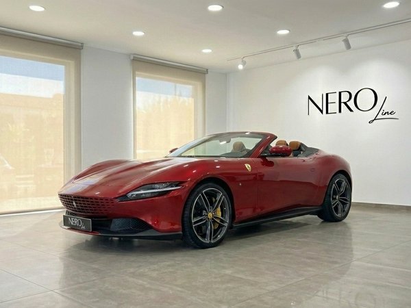 Ferrari Roma Spider — Front three-quarter view Barcelona showroom The 2023 racing red Ferrari Roma Spider convertible is showcased in a Barcelona showroom, featuring its elegant front three-quarter view.