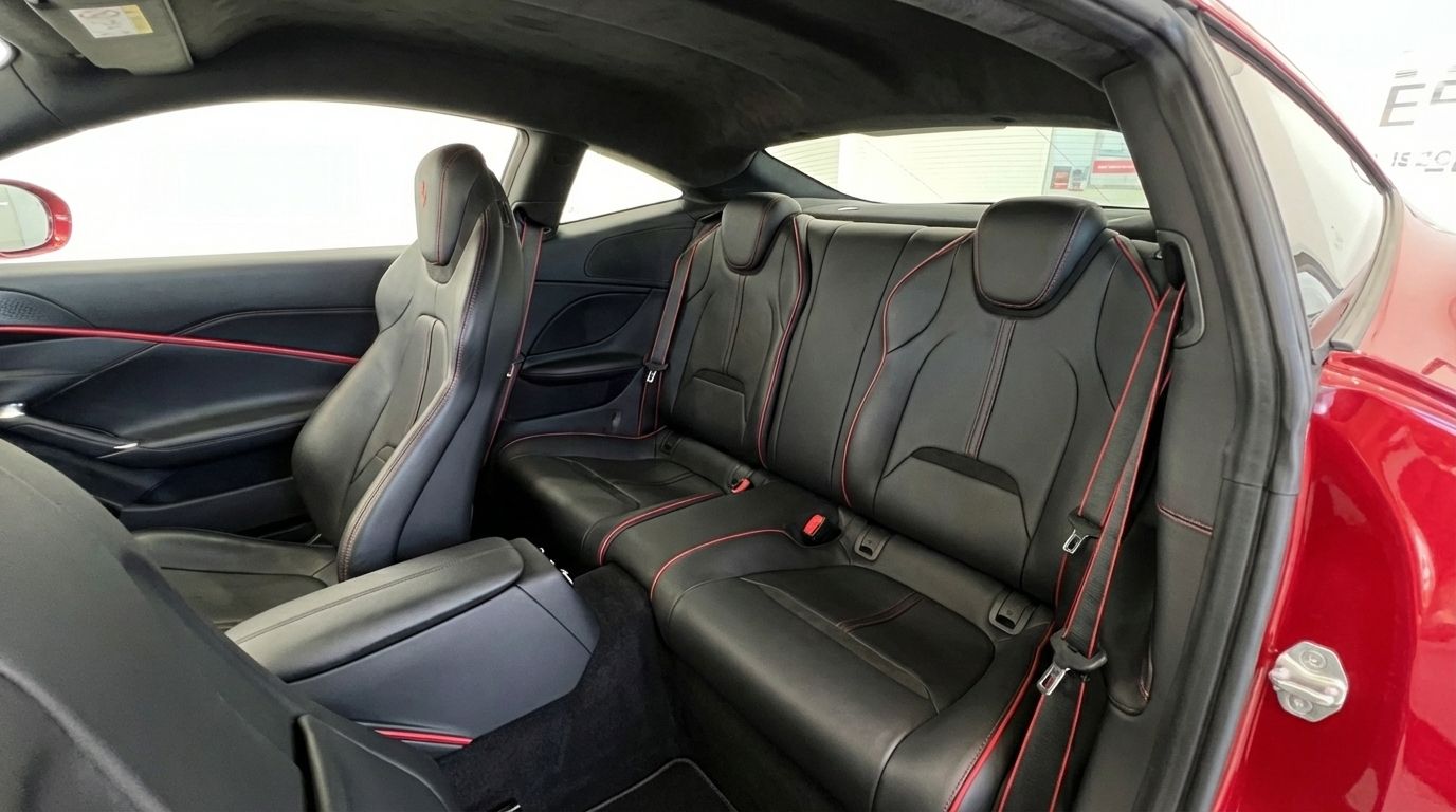 The interior of the Ferrari Roma in Barcelona, featuring black leather rear seats with elegant red stitching and the front passenger seat.