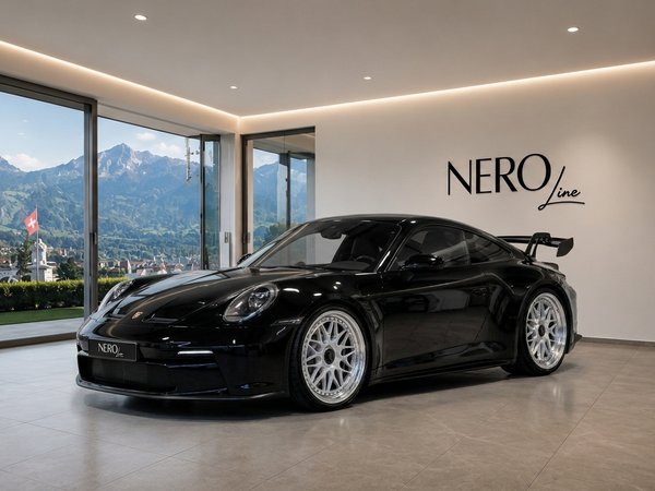 Porsche 911 992 GT3 — Luxury showroom in Zurich A sleek black Porsche 911 992 GT3 is parked in a modern showroom with a stunning mountain view of Zurich.
