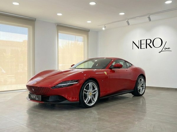 Ferrari Roma — Luxury supercar in Valencia showroom The striking red Ferrari Roma is showcased from a front three-quarter angle inside a modern, brightly lit showroom in Valencia.