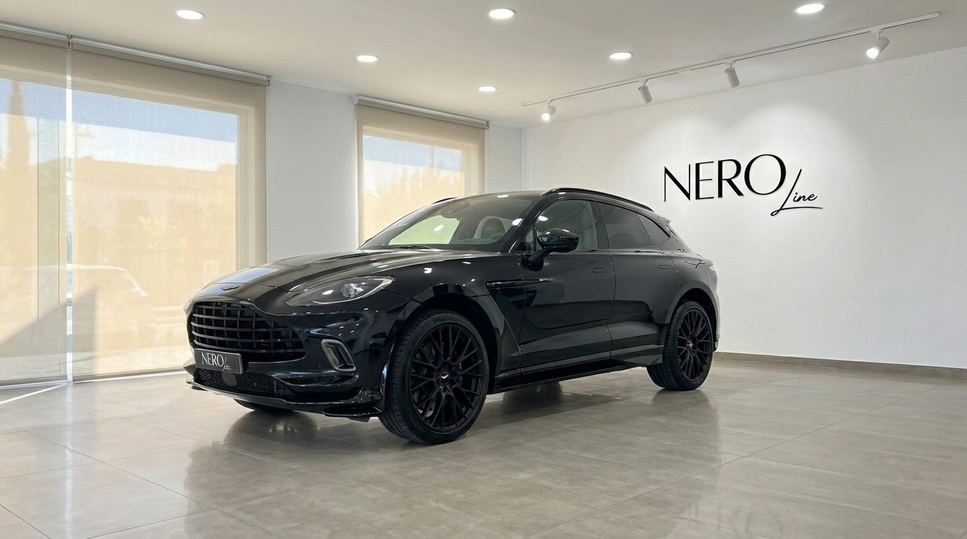 Aston Martin DBX 707 — Luxus-SUV auf Ibiza Der schwarze Luxus-SUV Aston Martin DBX 707 wird in einer modernen Ausstellungshalle auf Ibiza von vorne schräg gezeigt.