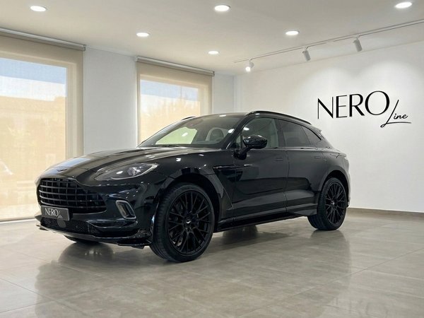 Aston Martin DBX 707 — Luxury SUV in Ibiza The black Aston Martin DBX 707 luxury SUV is showcased from a front three-quarter view inside a modern showroom in Ibiza.