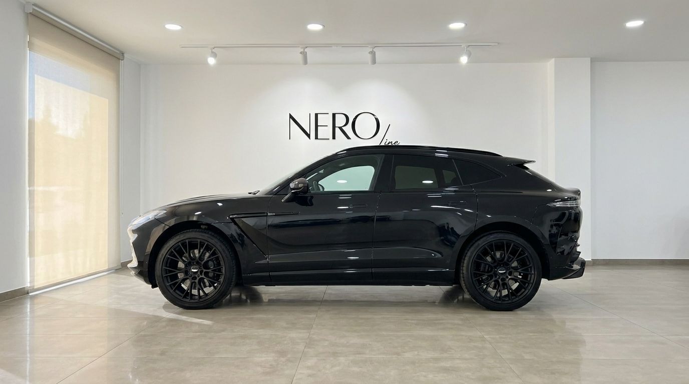 El elegante Aston Martin DBX 707 negro se muestra de perfil, estacionado en un moderno showroom de NEROline en Ibiza.
