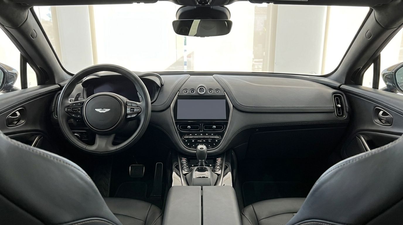 El lujoso interior de cuero negro del Aston Martin DBX 707, mostrando el volante, el salpicadero y la consola central en Ibiza.