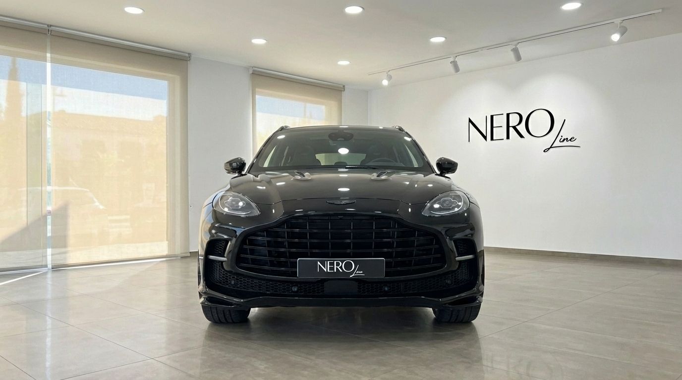 El SUV de alto rendimiento Aston Martin DBX negro 2025 se muestra prominentemente de frente en un concesionario en Madrid.