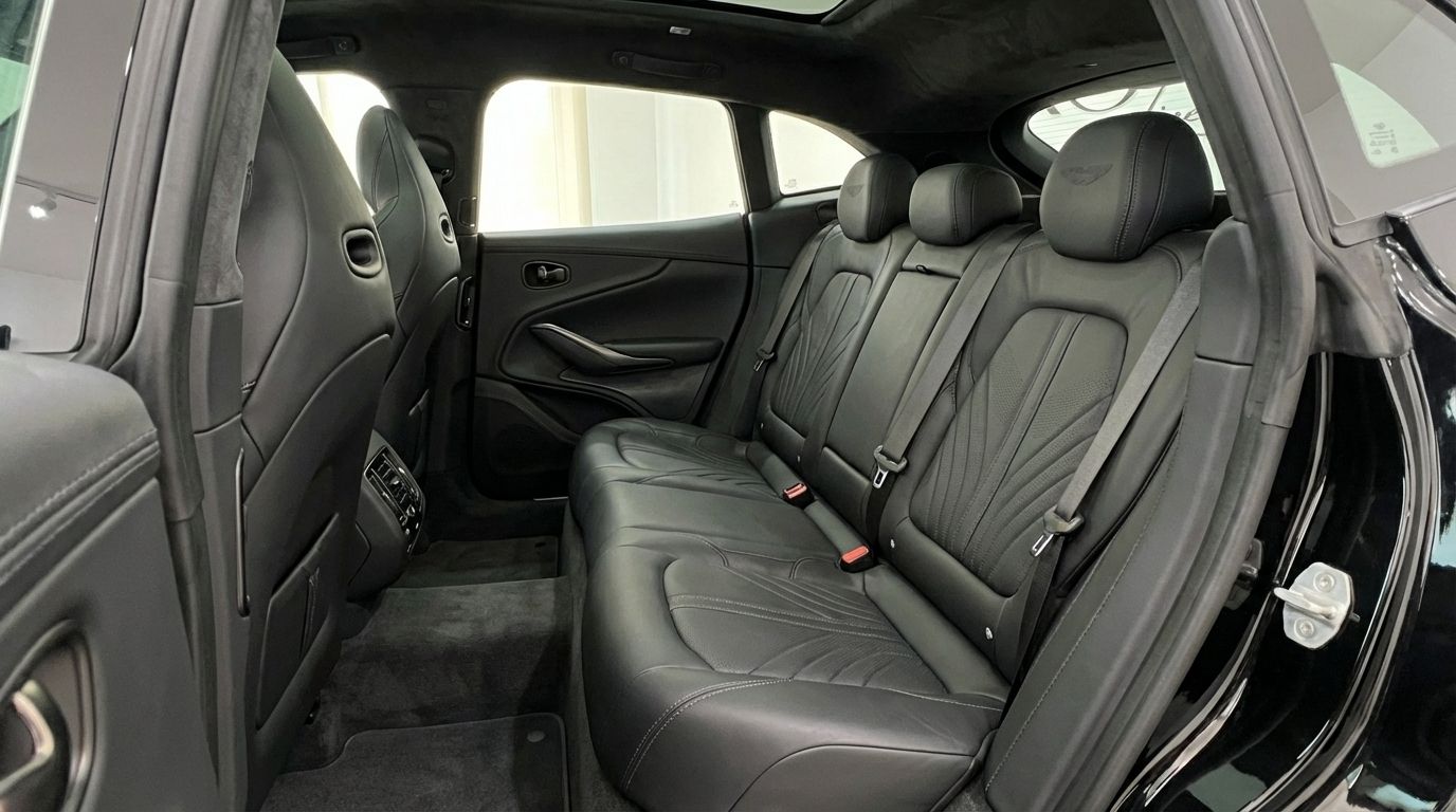 El lujoso interior trasero de cuero negro del Aston Martin DBX, mostrando asientos cómodos en Madrid.