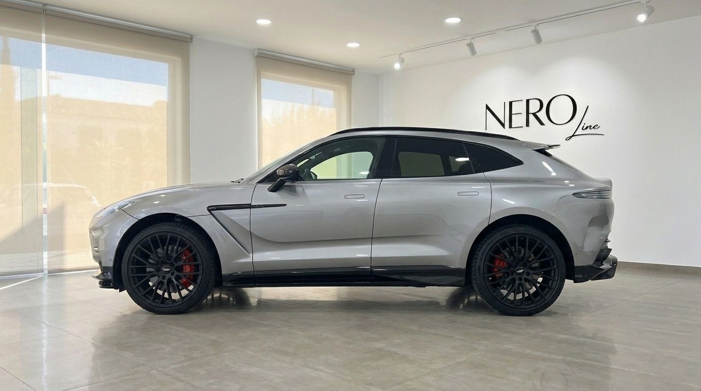 The metallic silver Aston Martin DBX707 is showcased in a side profile view inside a luxury showroom in Madrid.