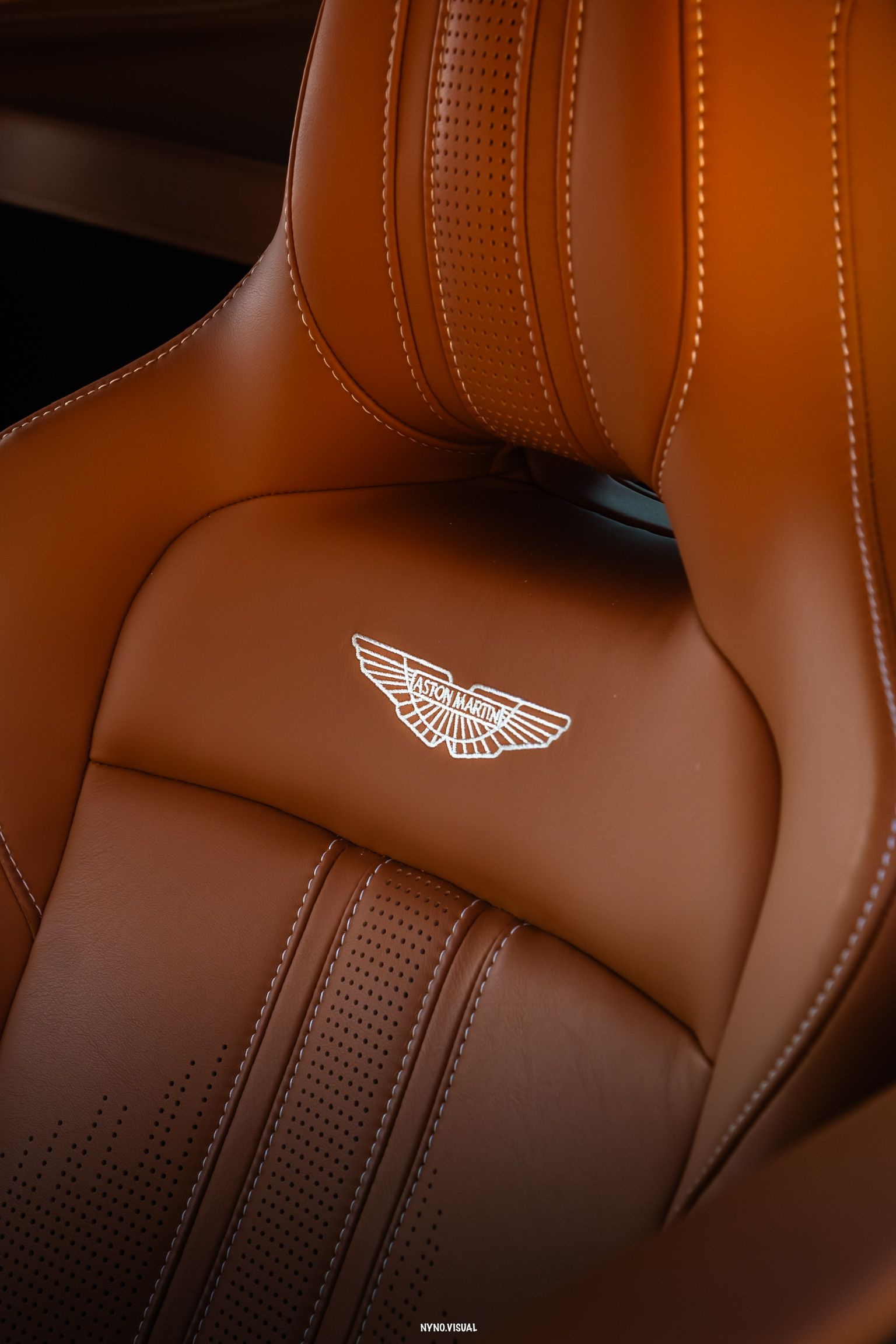 Close-up of the luxurious brown leather seat with white stitching and the embossed Aston Martin logo in the Vantage F1 Spec in Alicante.