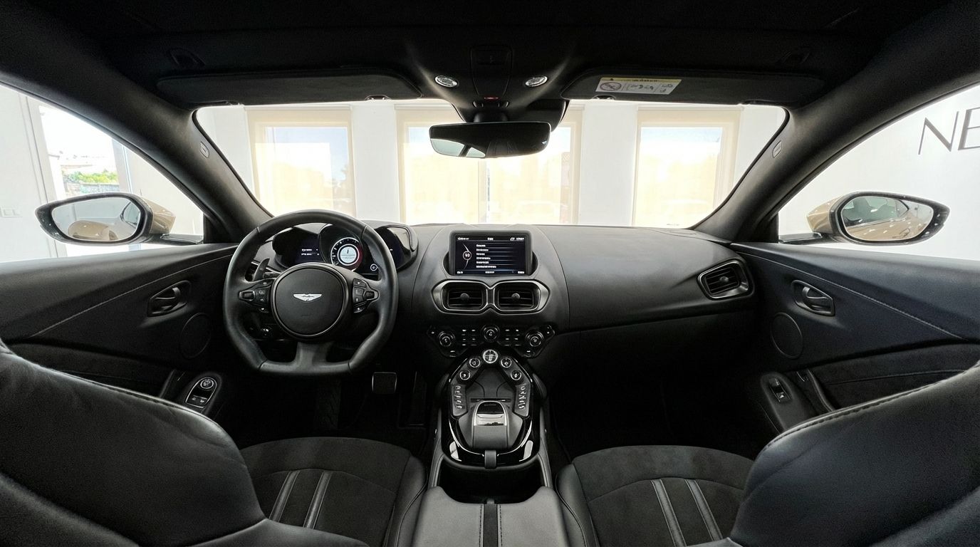 The luxurious black interior of the Aston Martin Vantage V8, showing the dashboard, steering wheel, and central console in Marbella.